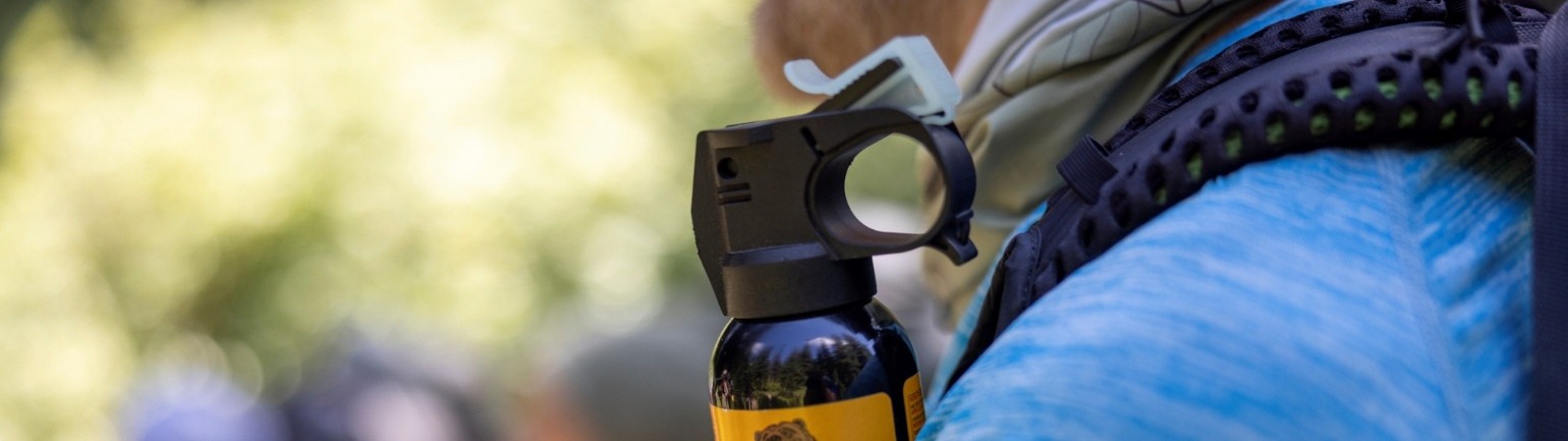 bearspray attached to a hiker's backpack